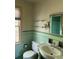 Vintage bathroom featuring mint tile, pedestal sink, window, and glass shelves at 6375 E 6Th Avenue Pkwy, Denver, CO 80220