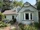 Close-up of the home's exterior with brick accents, a bay window, and colorful flower beds at 6375 E 6Th Avenue Pkwy, Denver, CO 80220