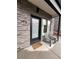 Home's inviting porch area featuring gray chairs, stone accents, and a modern, dark-framed front door at 1472 Yates St, Denver, CO 80204