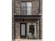 Close-up of a home's entrance with stone accents, black trim, and an inviting outdoor seating area at 1472 Yates St, Denver, CO 80204