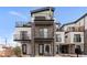 Modern townhomes featuring stacked balconies, stone facade accents, and contemporary design at 1472 Yates St, Denver, CO 80204