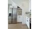 Modern kitchen area featuring stainless steel fridge, sleek white cabinets, and marble countertop at 1472 Yates St, Denver, CO 80204