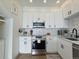 Well-lit kitchen features white cabinets, stainless steel appliances, light countertops, and hardwood floors at 1472 Yates St, Denver, CO 80204