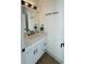 Stylish powder room featuring white cabinetry, a marble countertop, and modern black fixtures at 1472 Yates St, Denver, CO 80204