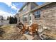 Charming backyard patio with wooden chairs, grill, and a view of the brick exterior of the house at 1022 Spruce St, Denver, CO 80230