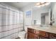 Functional bathroom featuring a single sink vanity and a shower with colorful striped curtain at 1022 Spruce St, Denver, CO 80230