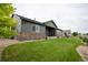 Backyard featuring a well-maintained lawn and covered patio with stone accents at 11259 Kalispell St, Commerce City, CO 80022
