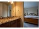 Bathroom featuring granite countertops, wooden cabinets, and an adjoining bedroom at 11259 Kalispell St, Commerce City, CO 80022