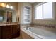 Inviting bathroom showcasing a soaking tub, decorative tile accents, and a window for natural light at 11259 Kalispell St, Commerce City, CO 80022