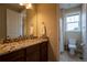 Bathroom featuring granite countertops, wooden cabinets, and tiled floors at 11259 Kalispell St, Commerce City, CO 80022