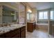 Luxurious bathroom featuring double vanities, granite countertops, a soaking tub, and a separate shower at 11259 Kalispell St, Commerce City, CO 80022