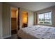 Bedroom featuring unique wooden bedframe, view of the backyard, and multiple entry ways at 11259 Kalispell St, Commerce City, CO 80022