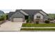 Charming home featuring a two-car garage, stone accents, a well-manicured lawn, and tasteful landscaping at 11259 Kalispell St, Commerce City, CO 80022