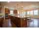 Modern kitchen has granite island with pendant lights and adjacent dining area at 11259 Kalispell St, Commerce City, CO 80022