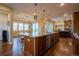Open kitchen with granite countertops, a large island, pendant lighting, and views of the living area and backyard at 11259 Kalispell St, Commerce City, CO 80022