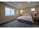 Serene bedroom with plush carpet, tray ceiling, and large window providing natural light and neighborhood views at 11259 Kalispell St, Commerce City, CO 80022