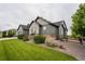 Landscaped home exterior featuring stone accents, a lush lawn, and a charming wooden fence at 11259 Kalispell St, Commerce City, CO 80022