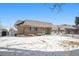 Charming brick home in winter with snow-covered lawn at 1832 Simms St, Lakewood, CO 80215