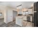 Bright kitchen featuring gray floors, white cabinets, an island with stone countertop, and stainless steel appliances at 1832 Simms St, Lakewood, CO 80215