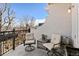 Cozy balcony with neutral outdoor seating and overhead view of nearby homes and treeline at 1489 Steele St # 310, Denver, CO 80206
