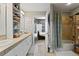 Well-lit bathroom with double sinks, neutral tile, and a shower over tub with a shower curtain at 1489 Steele St # 310, Denver, CO 80206