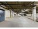 Well-lit parking garage with overhead piping and concrete pillars and floors at 1489 Steele St # 310, Denver, CO 80206