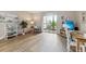 Living room with wood-like floors, balcony access, and a wall-mounted television at 13606 E Bates Ave # 208, Aurora, CO 80014