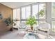 Bright sunroom with wicker chairs and large windows at 13606 E Bates Ave # 208, Aurora, CO 80014