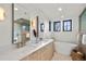 Bright bathroom features double vanity with modern fixtures, soaking tub, and glass enclosed shower at 4445 Wolff St, Denver, CO 80212