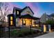 Charming two-story home boasting a stone facade, black trim, and a covered porch, complemented by a wrought iron fence at 4445 Wolff St, Denver, CO 80212