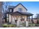 Charming two-story home featuring a fenced yard and an inviting front porch with stone details at 4445 Wolff St, Denver, CO 80212