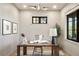 Well-lit home office featuring a wooden desk, large window, and decoratively framed art at 4445 Wolff St, Denver, CO 80212