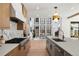 Modern kitchen with a white island, wooden cabinets, stainless steel appliances, and open access to the dining area at 4445 Wolff St, Denver, CO 80212