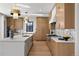 Modern kitchen with wood cabinets, a marble backsplash, stainless steel appliances, and a sleek island for cooking and dining at 4445 Wolff St, Denver, CO 80212