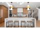 Bright kitchen with wood cabinets, a white countertop island with barstools, modern pendants, and stainless steel appliances at 4445 Wolff St, Denver, CO 80212
