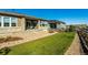 Landscaped backyard featuring a well-maintained lawn, stone accents, and a charming covered patio at 7334 Canyonpoint Rd, Castle Pines, CO 80108