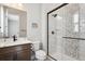 A bathroom featuring a walk-in shower with mosaic tile, a vanity with a white countertop, and modern fixtures at 7334 Canyonpoint Rd, Castle Pines, CO 80108