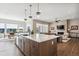 Modern kitchen featuring an island with seating, stainless steel appliances, quartz countertops, and seamless flow into living area at 7334 Canyonpoint Rd, Castle Pines, CO 80108