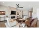 Cozy living room area featuring a stone fireplace, a leather sofa, and hardwood flooring at 7334 Canyonpoint Rd, Castle Pines, CO 80108