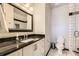 Bathroom with a marble countertop, black-framed mirror, and tiled shower at 5352 Pinyon Jay Rd, Parker, CO 80134