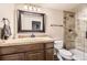 Bathroom with wooden cabinets, tan countertops, and a walk-in shower at 5352 Pinyon Jay Rd, Parker, CO 80134