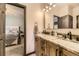 Bathroom sink with marble countertops, wooden cabinets, and a view into the bedroom at 5352 Pinyon Jay Rd, Parker, CO 80134