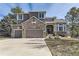 Beautiful two-story home with a brick-and-siding exterior, three-car garage, and well-manicured front yard at 5352 Pinyon Jay Rd, Parker, CO 80134