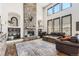 Stunning living room with a floor-to-ceiling stone fireplace, large windows, and hardwood floors at 5352 Pinyon Jay Rd, Parker, CO 80134