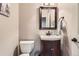 Powder room with a dark vanity, granite countertop, and decorative accents at 5352 Pinyon Jay Rd, Parker, CO 80134