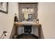 Charming powder room with black and white patterned wall and wood vanity at 5352 Pinyon Jay Rd, Parker, CO 80134