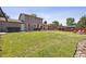 Spacious backyard with grass, a patio dining area, and an area for a fire pit at 8445 Lamar Dr, Arvada, CO 80003