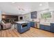 Contemporary kitchen with a center island, stainless appliances, blue cabinetry, and open access to the living room at 8445 Lamar Dr, Arvada, CO 80003