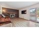 Spacious living area with a brick fireplace, sliding glass doors to the backyard, and hardwood floors at 8445 Lamar Dr, Arvada, CO 80003