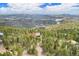 Aerial view of a forested property with mountain views and a house featuring solar panels on the roof at 116 Ramona Rd, Golden, CO 80403